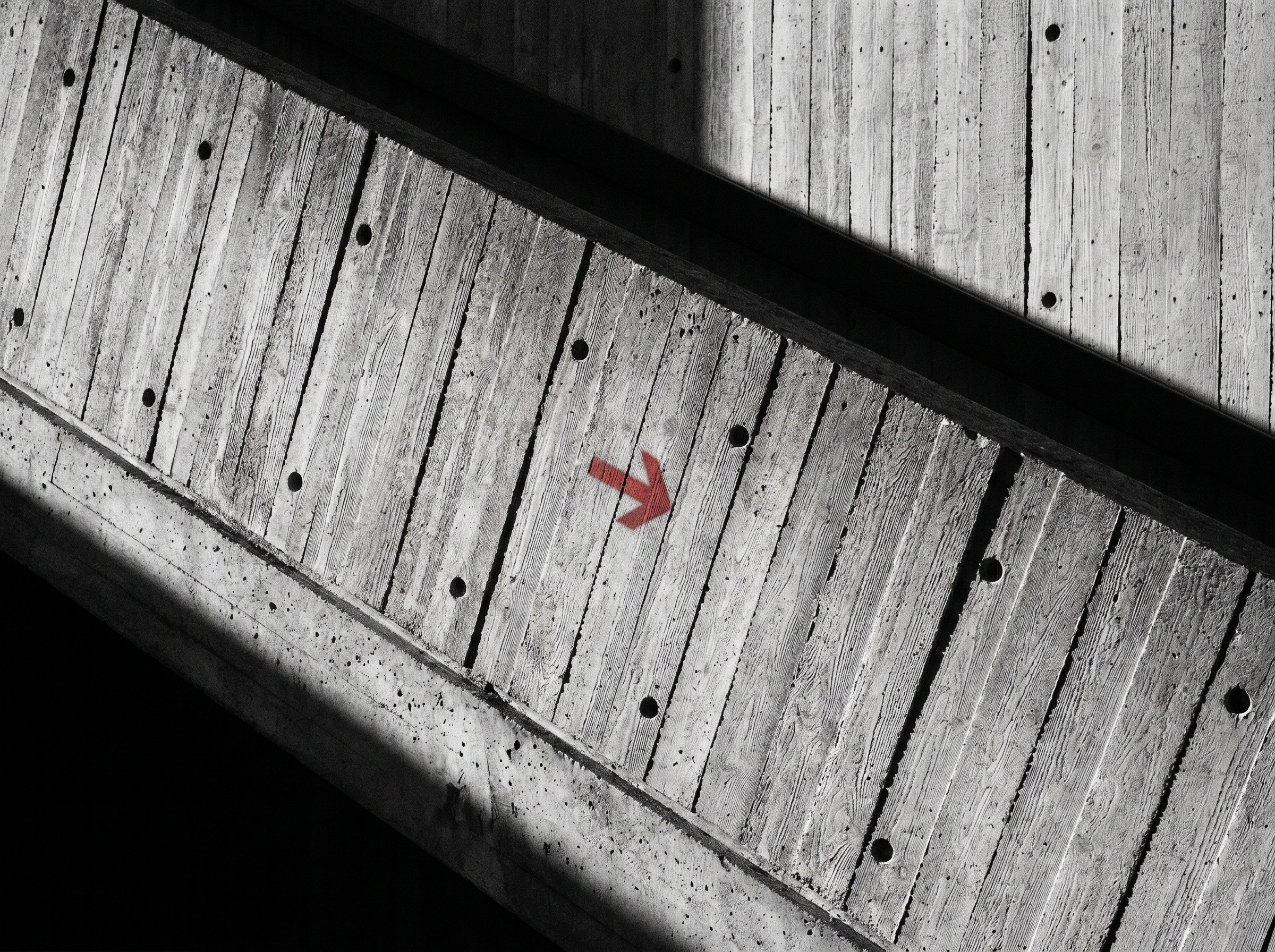 Brutalist concrete ramp with a red directional arrow